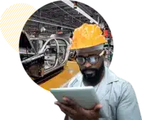 Man in automotive plant referencing a tablet