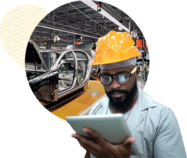 Man in automotive plant referencing a tablet